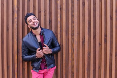 Arap genç adam hoş görünümlü duvar ve gülümsüyor, Laug standları