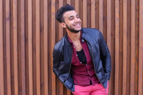 Joli jeune homme arabe se tient près du mur et sourit, Laug — Photo