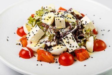 Beyaz bac üzerinde yuvarlak plaka üzerinde beyaz soslu kırmızı balık salatası