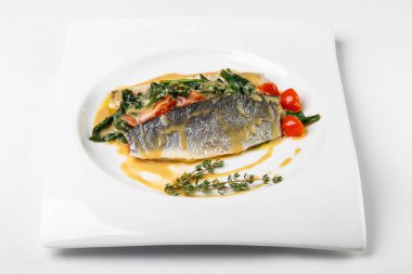 Beyaz WHI üzerinde kare plaka üzerinde hafif soslu sebzeli balık