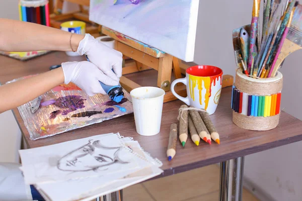 Artista extrai tinta de tubos na paleta para misturar cores t — Fotografia de Stock