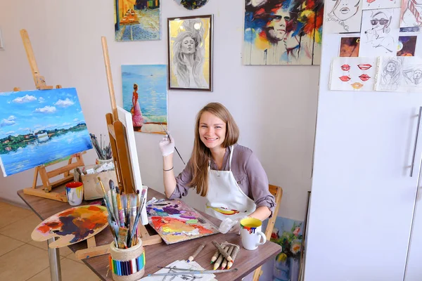 Girl Sits on Stool at Easel And Writing Painting, Uses Brush to — Stock Photo, Image