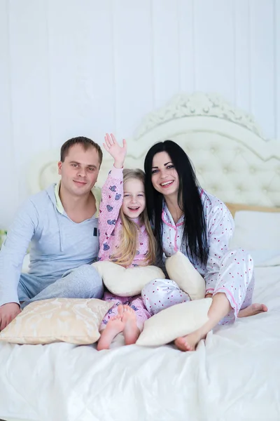 Portrait happy family in pajamas smiling and looking at camera i