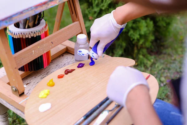 Mujeres artistas exprimidas a mano de tubos pintura al óleo sobre madera pálida —  Fotos de Stock