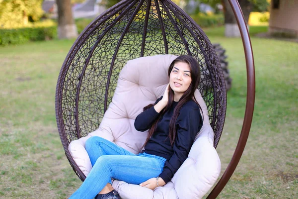 Pretty attractive woman sits comfortably in chair suspended by p — Stock Photo, Image