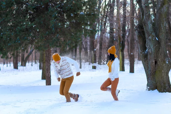 Retrato de pareja joven sonriendo y jugando bolas de nieve en invierno — Foto de Stock