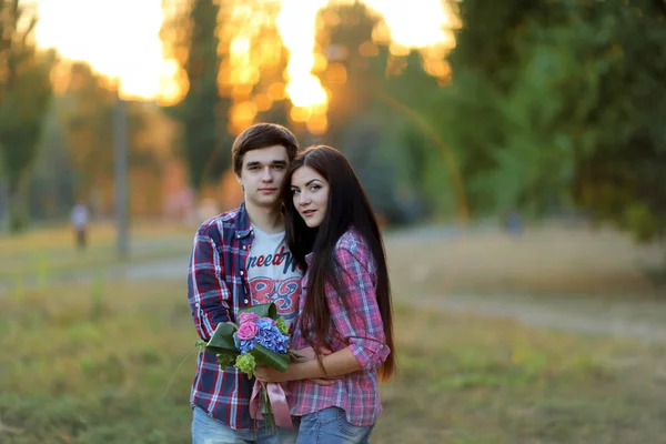 Jovem casal bonito abraçando e sorrindo ao pôr do sol no verão — Fotografia de Stock