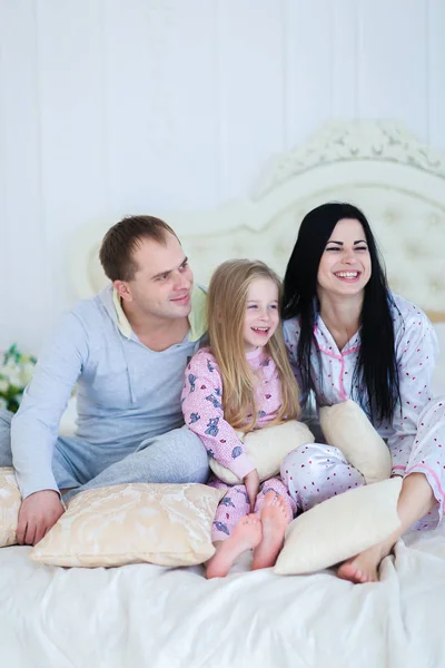 Portrait of happy family in pajamas smiling and looking at camer