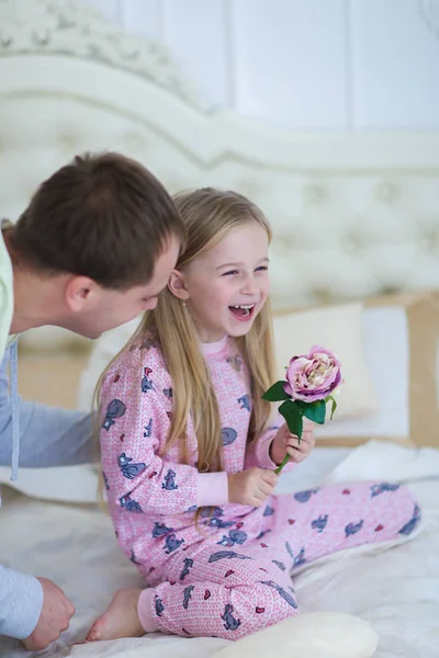 Dad tickles daughter, played with girl on bed at home