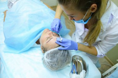 Kaşları dövme kadın efendi özel aygıt kaş üzerinde tutar.