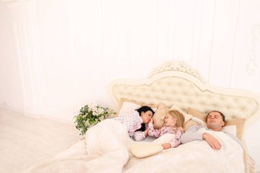 Anne, baba uyan kızım uyandı. Mutlu aile içinde beyaz bedr yalan