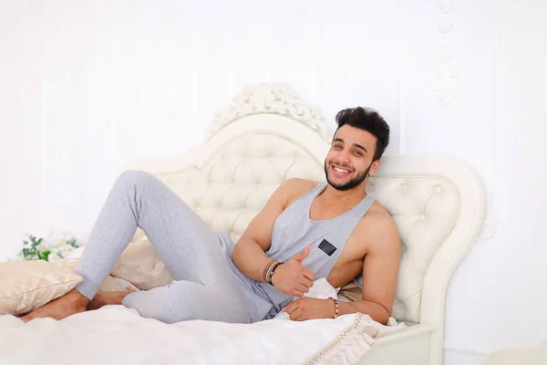 Portrait de jeune arabe se reposant sur une journée difficile sur le lit dans lumineux — Photo