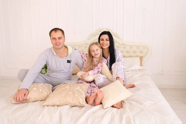 Portrait of happy family in pajamas smiling and looking at camer