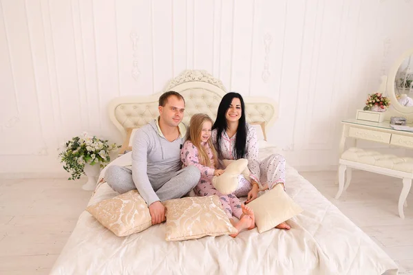 De gelukkige familie portret in pyjama glimlachen en kijken naar camera ik — Stockfoto