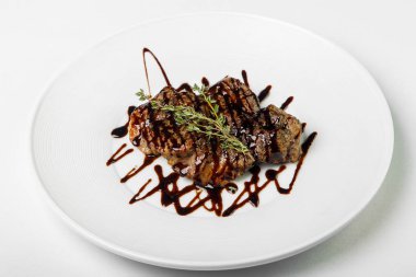 Sulu pişmiş et yuvarlak plaka üzerinde tatlı sos ile.