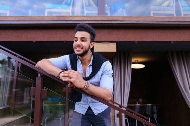 Meme üzerinde ha eğilerek yakışıklı erkek Arap görünüm gülümseyen genç