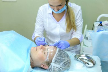 Kaşları dövme kadın efendi özel aygıt kaş üzerinde tutar.