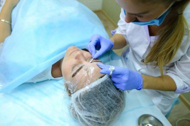 Kaşları dövme kadın efendi özel aygıt kaş üzerinde tutar.