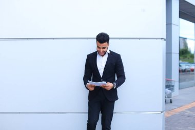 Gülümseyen, yakışıklı Arap girişimci öğrenci tutar ve d görünüyor