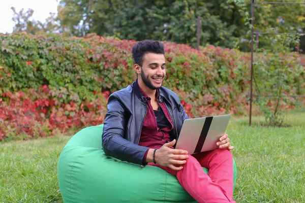 Succesvolle Arabisch jonge zakenman zit met Laptop in de stoel, S — Stockfoto