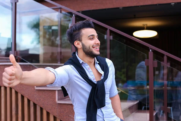 Χαρούμενος νεαρός άνδρας φαίνεται μουσουλμανική χαμογελώντας και δείχνοντας χειρονομία — Φωτογραφία Αρχείου