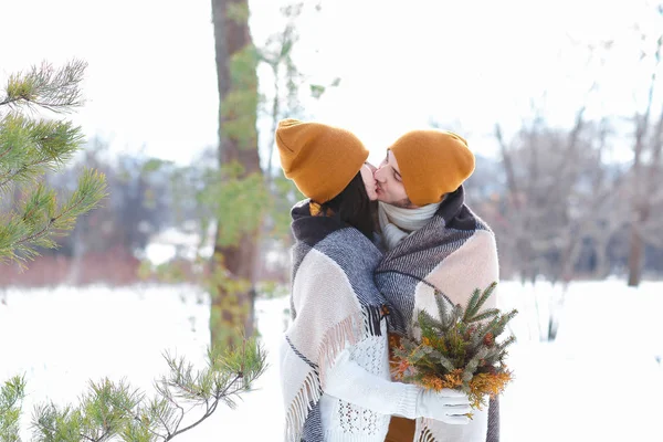 Портрет молодой пары, улыбающейся и обнимающей поцелуи зимой — стоковое фото