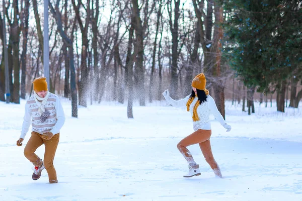 Retrato de pareja joven sonriendo y jugando bolas de nieve en invierno — Foto de Stock