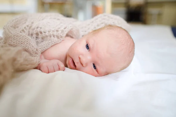 Newborn baby covered knitted blanket and lying on bed in sleepin — Stock Photo, Image