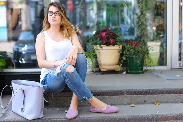 Jovem mulher no chão na rua olhando na câmera usando p — Fotografia de Stock