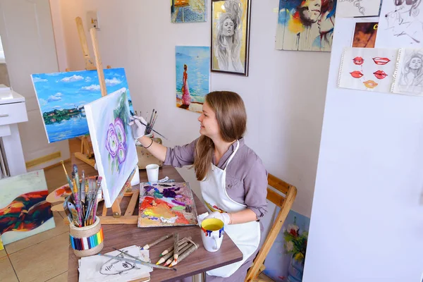 Girl Sits on Stool at Easel And Writing Painting, Uses Brush to — Stok Foto