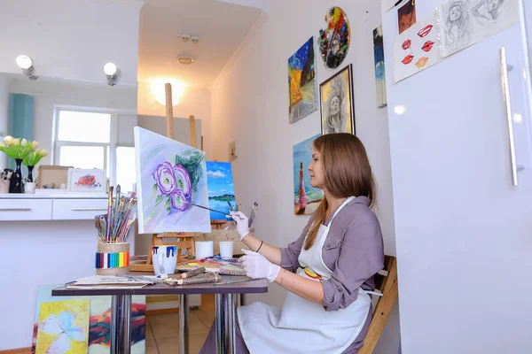 Girl Sits on Stool at Easel And Writing Painting, Uses Brush to — Stok Foto