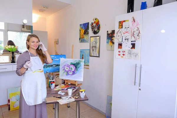 Artiste fille tient pinceau dans la main et dessine sur toile, ramasse Ph — Photo