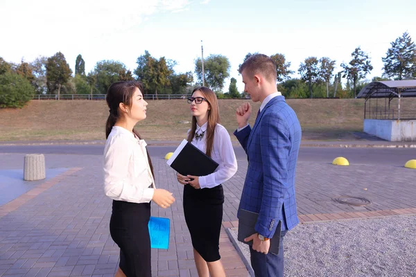 Three young successful businessman, students communicate, smilin