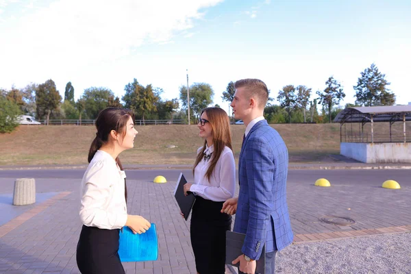 Three young successful businessman, students communicate, smilin