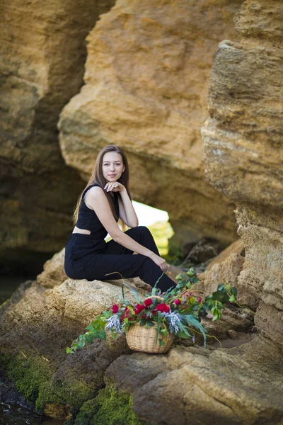 Porträtt av vacker ung kvinna med blommor på bakgrunden sto — Stockfoto