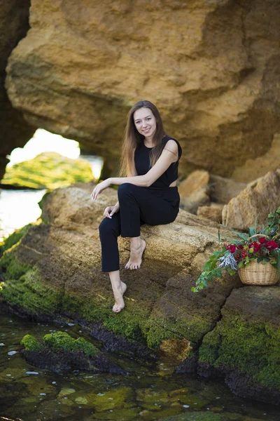 Porträt einer schönen jungen Frau mit Blumen auf dem Hintergrund — Stockfoto