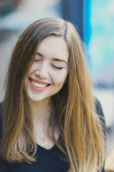 Joven chica atractiva con hoyuelos sonrisa y mira de cerca los ojos con el pelo largo y rubio — Foto de Stock