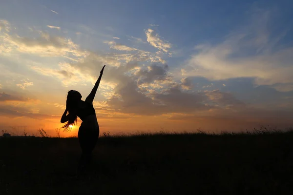Štíhlá dívka ukazuje různé pózy a tančí v pole venku — Stock fotografie