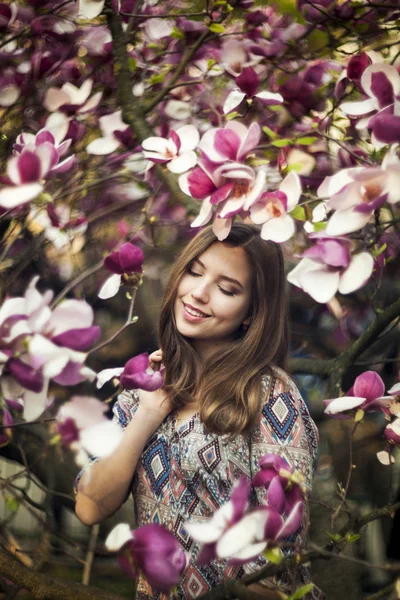 Unga attraktiva flicka leende med gropar nära den blomma magno — Stockfoto