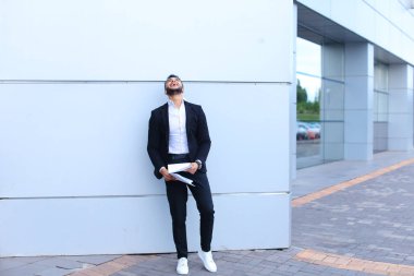 Genç erkek adam Arap işadamı gülüyor, sevinir başarı, tutun