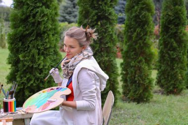 Güzel Avrupa görünüm sanatçı paleti ve fırçalar tutar bir