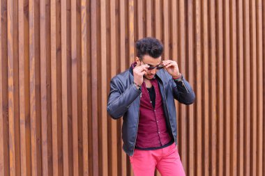 Kendine güvenen genç Arap adam poz ve kamera, tipler düzeltir