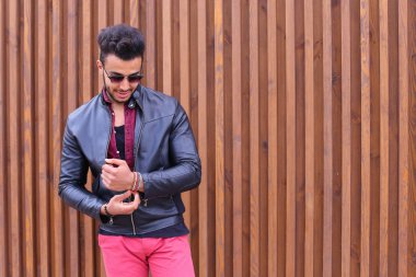 Kendine güvenen genç Arap adam poz ve kamera, tipler düzeltir