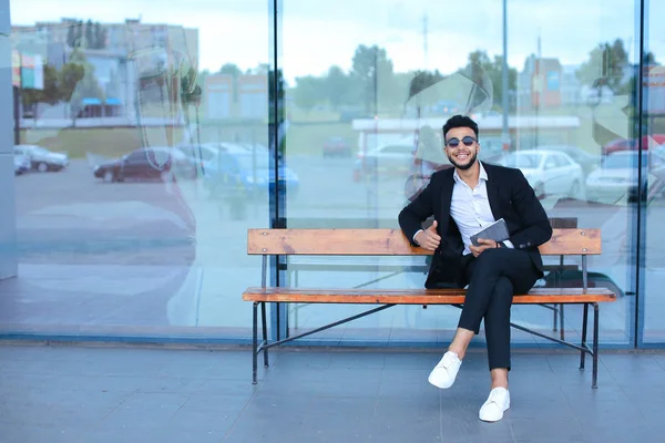 Hombre de traje árabe se pone gafas de sol con tableta cerca de negocios — Foto de Stock