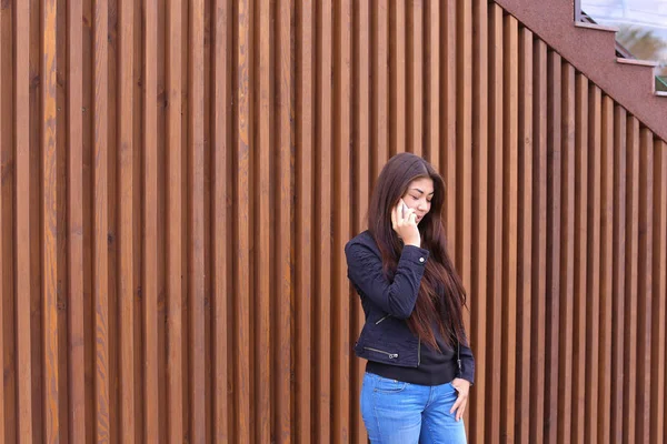 Linda mulher de cabelos escuros segura no telefone mão e falando, smi — Fotografia de Stock