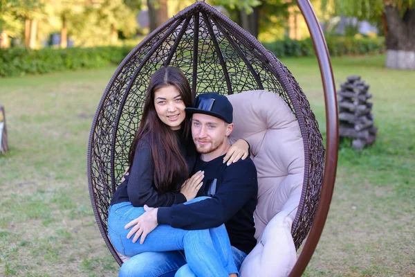 Jongen en meisje elkaar zitten geschorst stoel, elke o knuffelen — Stockfoto