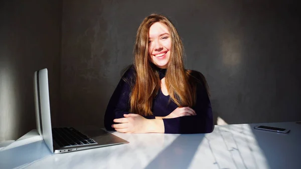 Retrato de hoyuelos chica joven con ordenador portátil, hermosa mujer sentada — Foto de Stock