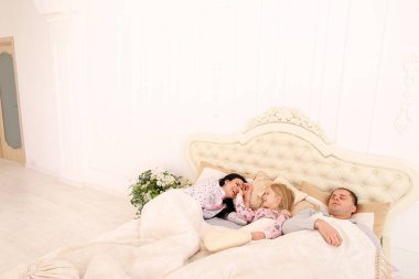 Küçük kızı uyanır anne yatakta sabah erken.