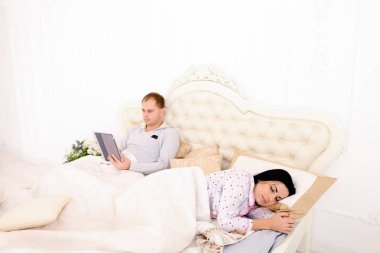 Koca inşaat Tablet üstünde ise beyaz yatakta uyuyan eşi