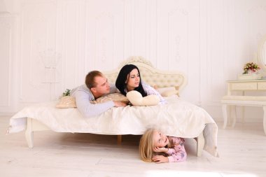 Kızı yatağın altında mı saklanıyor anne ve baba öpücük ve çocuk için arıyorsunuz